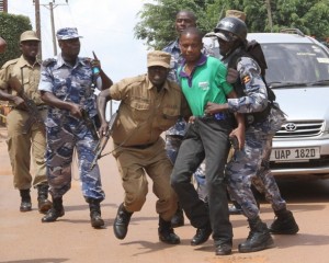 Associated Press/Rebecca Vassie - Ugandan police arrest a journalist outside the Daily Monitor offices Wednesday, May 29, 2013. Journalists struggled with police as they protest outside the Daily Monitor newspaper head office, in downtown Kampala, Uganda, Ugandan police are occupying one of Kampala daily's premises for a tenth straight day amid growing outrage over the government's seizure of the newspaper that published an army general's concerns about an alleged secret plot for the president's son to succeed his father. (AP Photo/Rebecca Vassie)