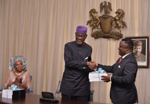 Cross River State Governor, Prof. Ben Ayade (R)receiving the handing over notes from his predecessor, Sen. Liyel Imoke while Imoke's wife, Obioma watched in Calabar