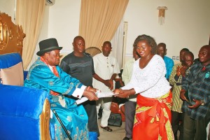 King Dumaro Owaba, Obanobha 111 of Ogbia Kingdom in Bayelsa handing over endorsement documents to Mr Faith Wilkinson, President of the Oloibiri Oil and Gas Festival Organising Committee at his Palace.
